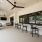 Outdoor lounge space with barstools and a tv